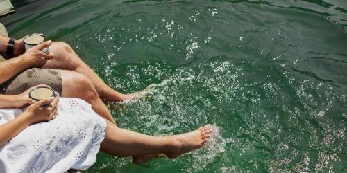 barefoot couple holding mugs of coffee