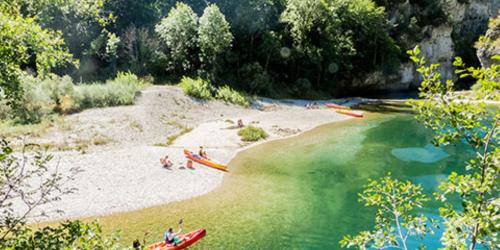 Group of kayakers paddling on the emerald waters of the Tarn at the foot of the spectacular cliffs in Loz�re.
